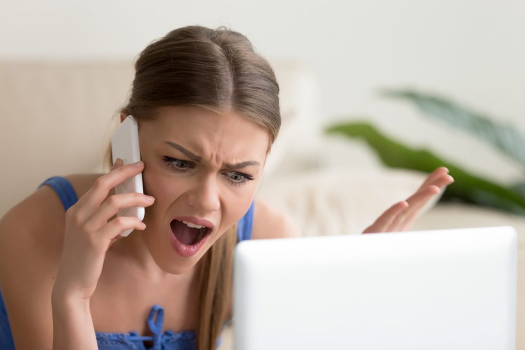 Angry dissatisfied young woman calling customer support, arguing on phone